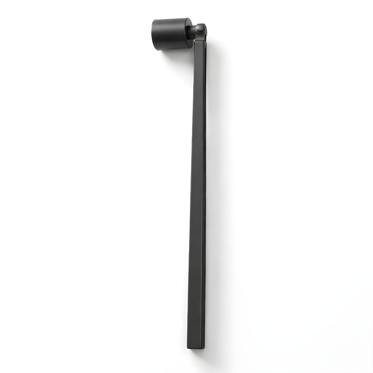 Professional candle snuffer in matte black finish resting next to a luxury candle.