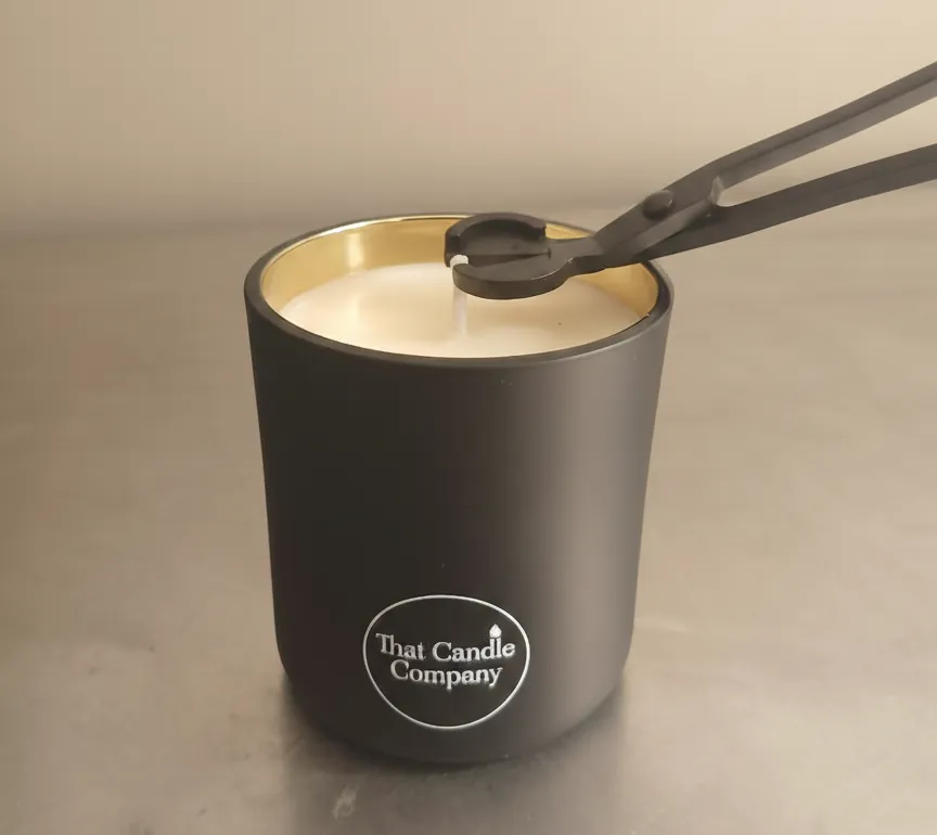 That Candle Company Professional Wick Trimming Tool being used on a candle