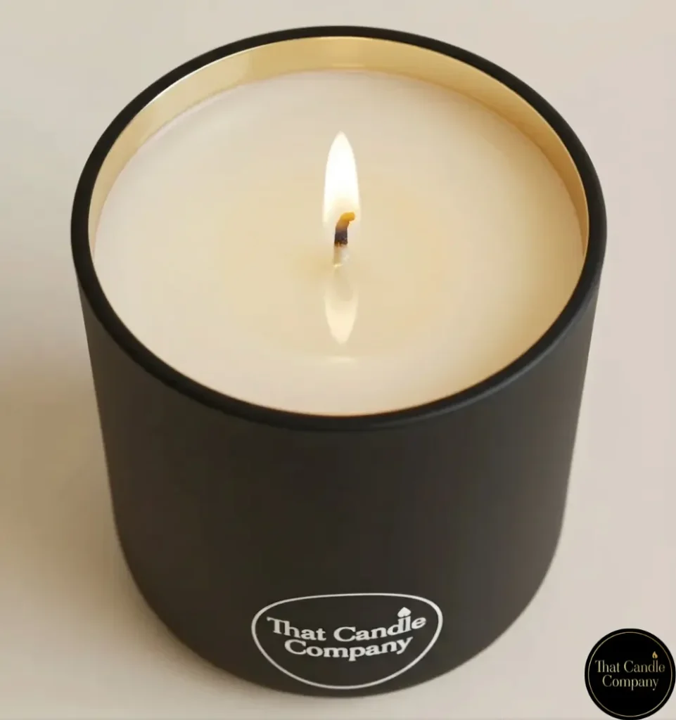 's matte black candle with a lit flame and a perfectly even, edge-to-edge liquid melt pool, illustrating how a correctly designed luxury candle should burn