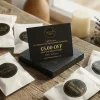Scented wax melt samples in luxury white packaging with a black and gold £5 off gift card on a rustic wooden surface.